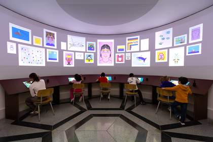 Children drawing on digital screens with digital artworks appearing on the walls of the large curved room